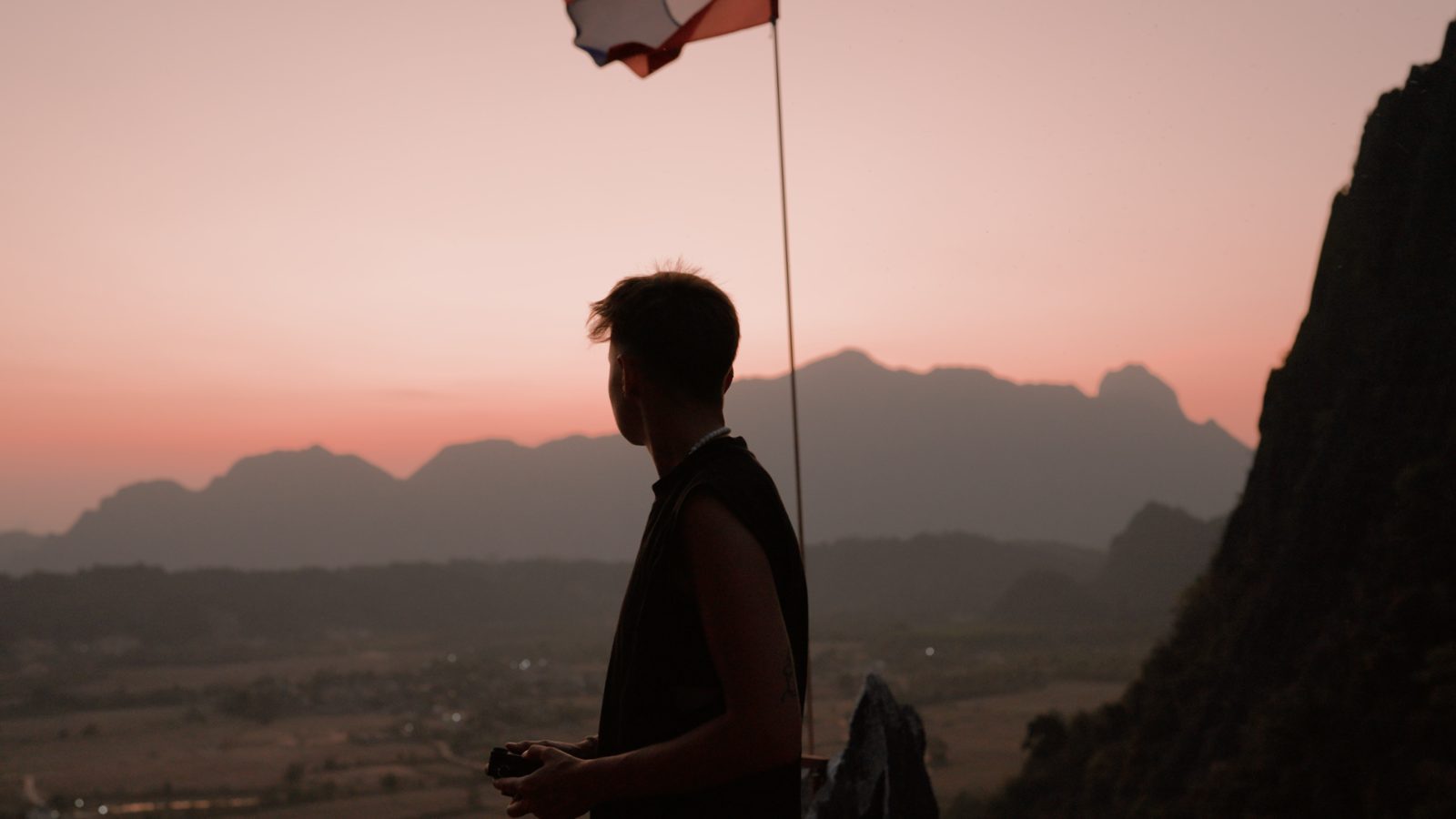 Filmmaker silhouette over a valley at sunset